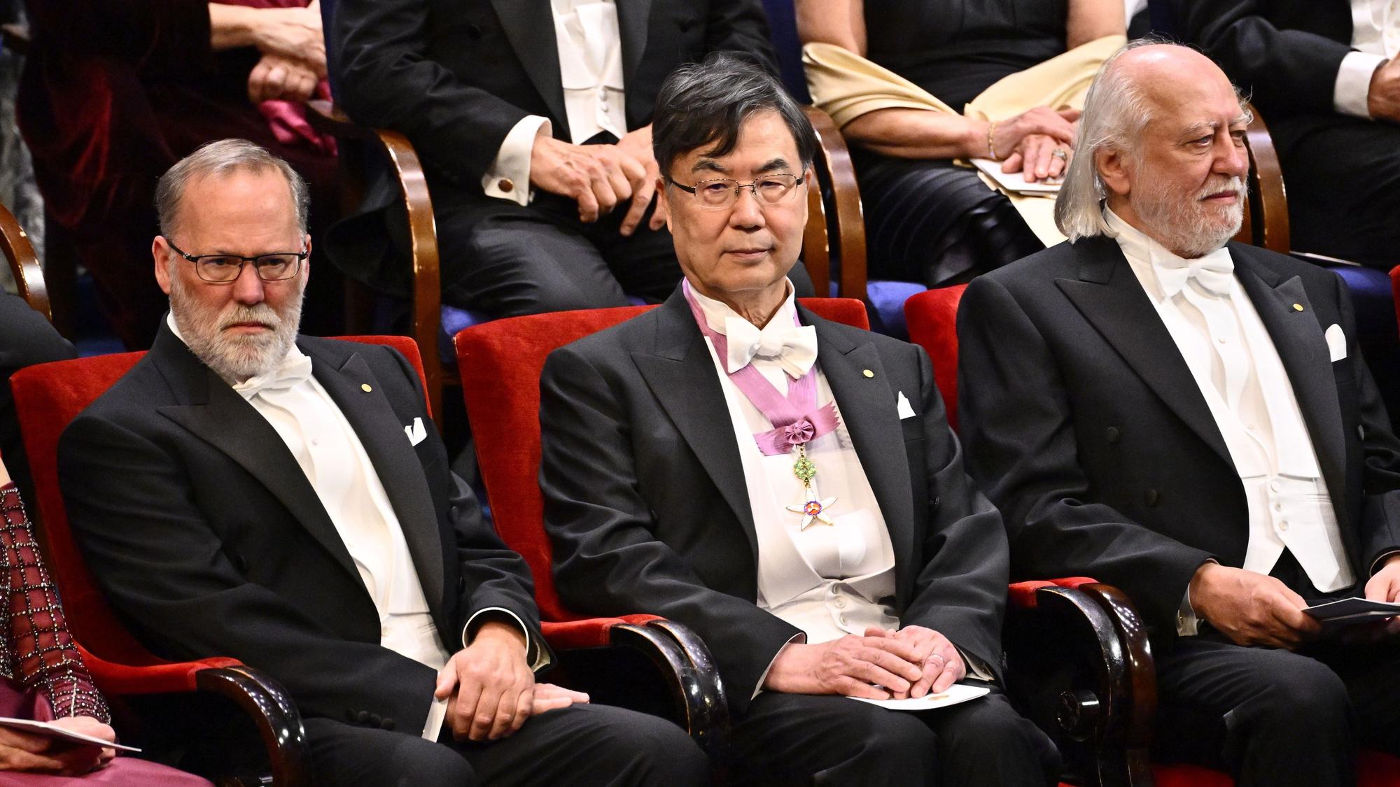 Die Nobelpreisträger für Physiologie oder Medizin Fred Ramsdell (l) und Shimon Sakaguchi sitzen 2025 neben dem Literaturnobelpreisträger László Krasznahorkai (r) während der Nobelpreisverleihung in der Stockholmer Konzerthalle (Archivbild)