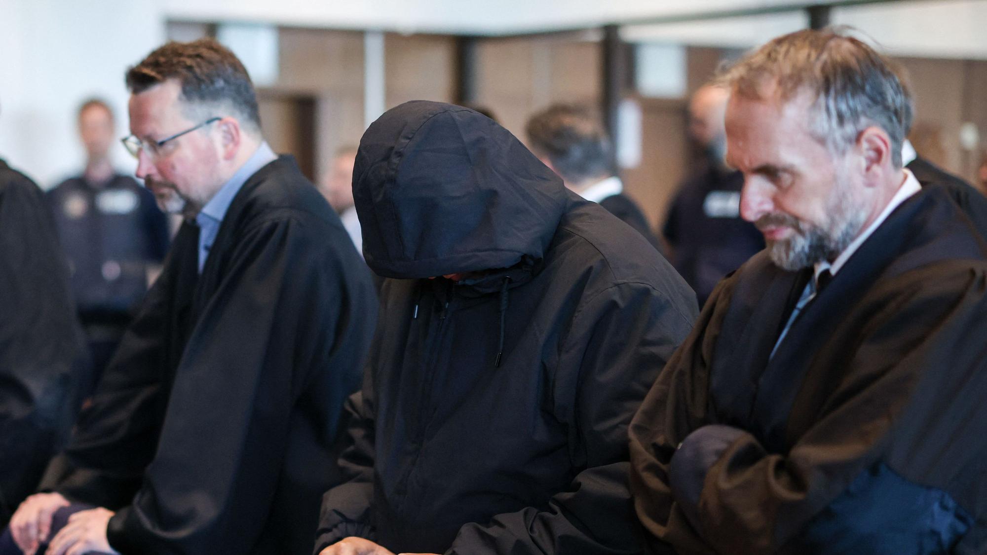Köln: Ein Angeklagter steht neben den Verteidigern im Gerichtssaal. Der Raubüberfall in einer Hürther Lagerhalle gilt als Auslöser einer massiven Gewaltspirale, die als „Kölner Drogenkrieg“ bekannt wurde.