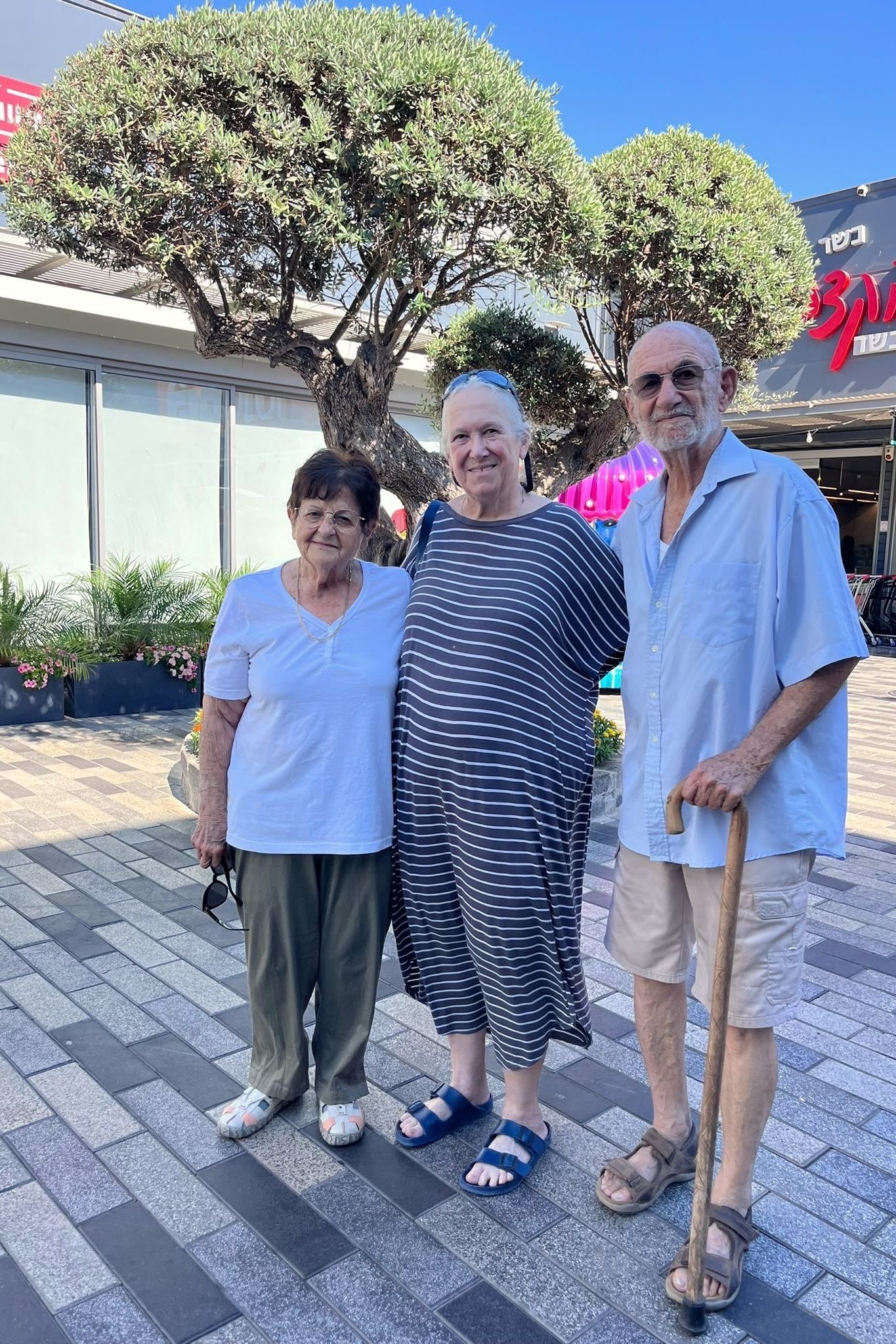 Die Deutsch-Israelin und frühere Geiseln Margalit Moses (M) steht mit ihrem Bruder Chanan Cohen (r) und dessen Frau Edna Cohen vor einem Einkaufszentrum.