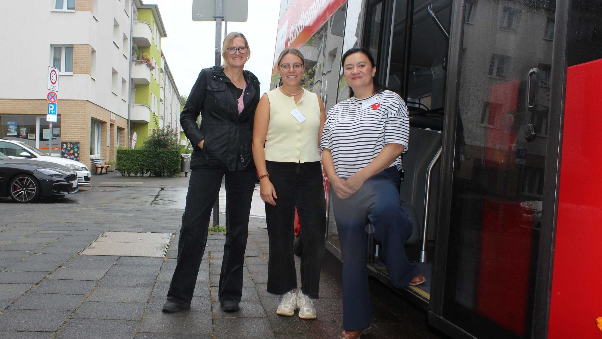 Organisatorin Elizaveta Khan (rechts) zusammen mit Birgit Werning (links) und Laura dos Santos vom Amt für Integration und Vielfalt während der Bustour zu Interkulturellen Zentren.