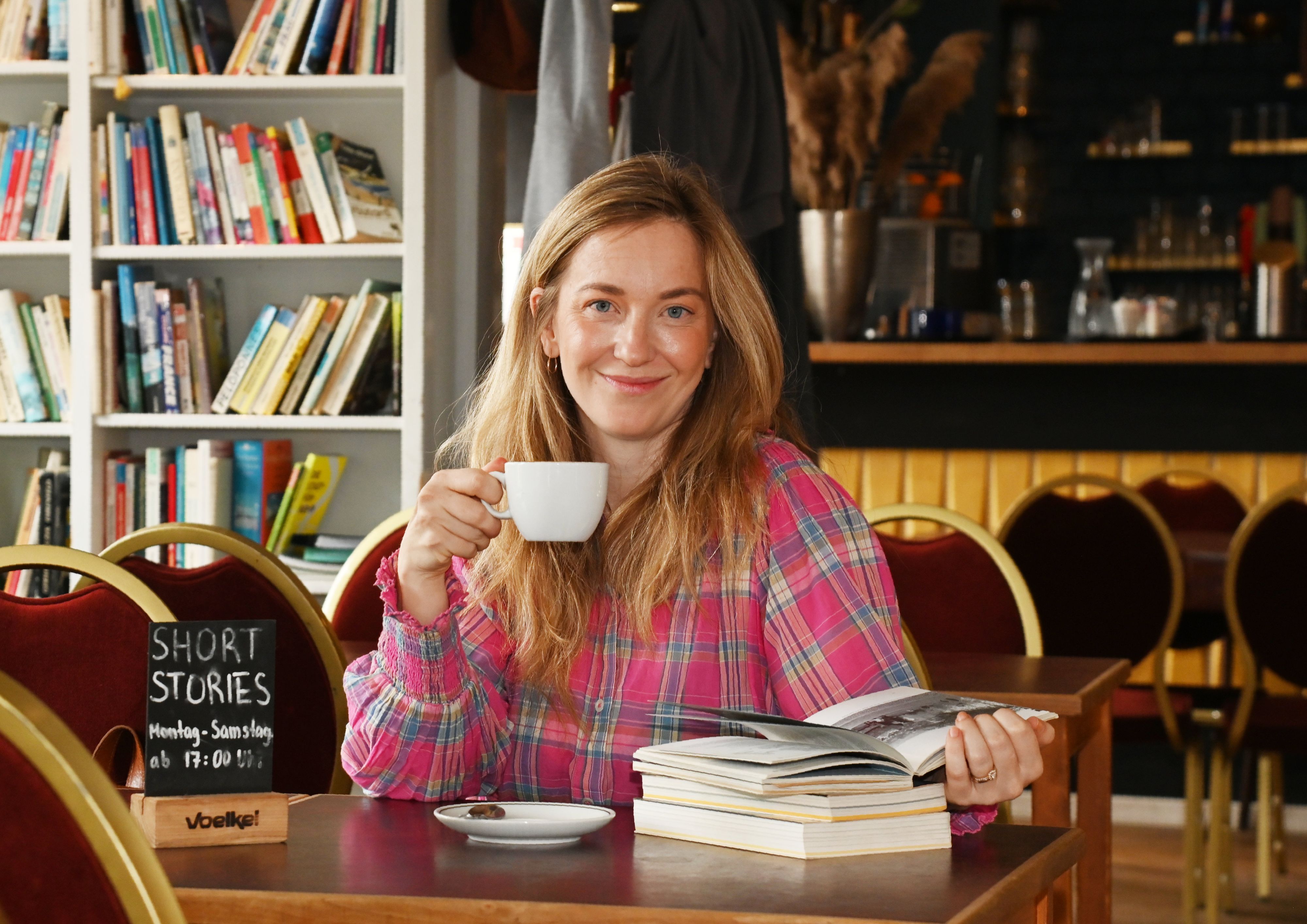 Johanna Flock mit Buch und Kaffee