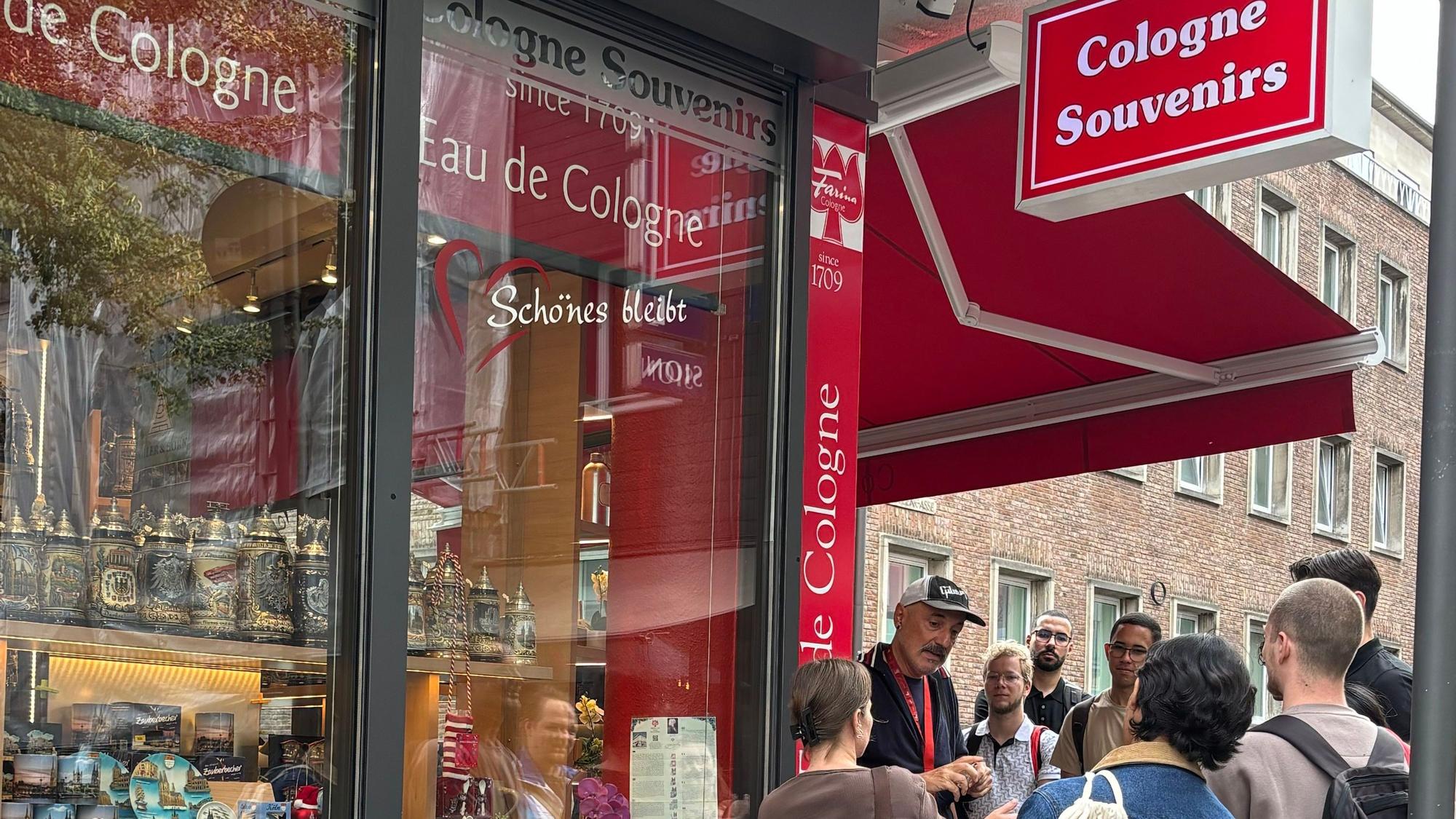 Eine Stadtführung hält vor dem Souvenirshop in der Kölner Altstadt.