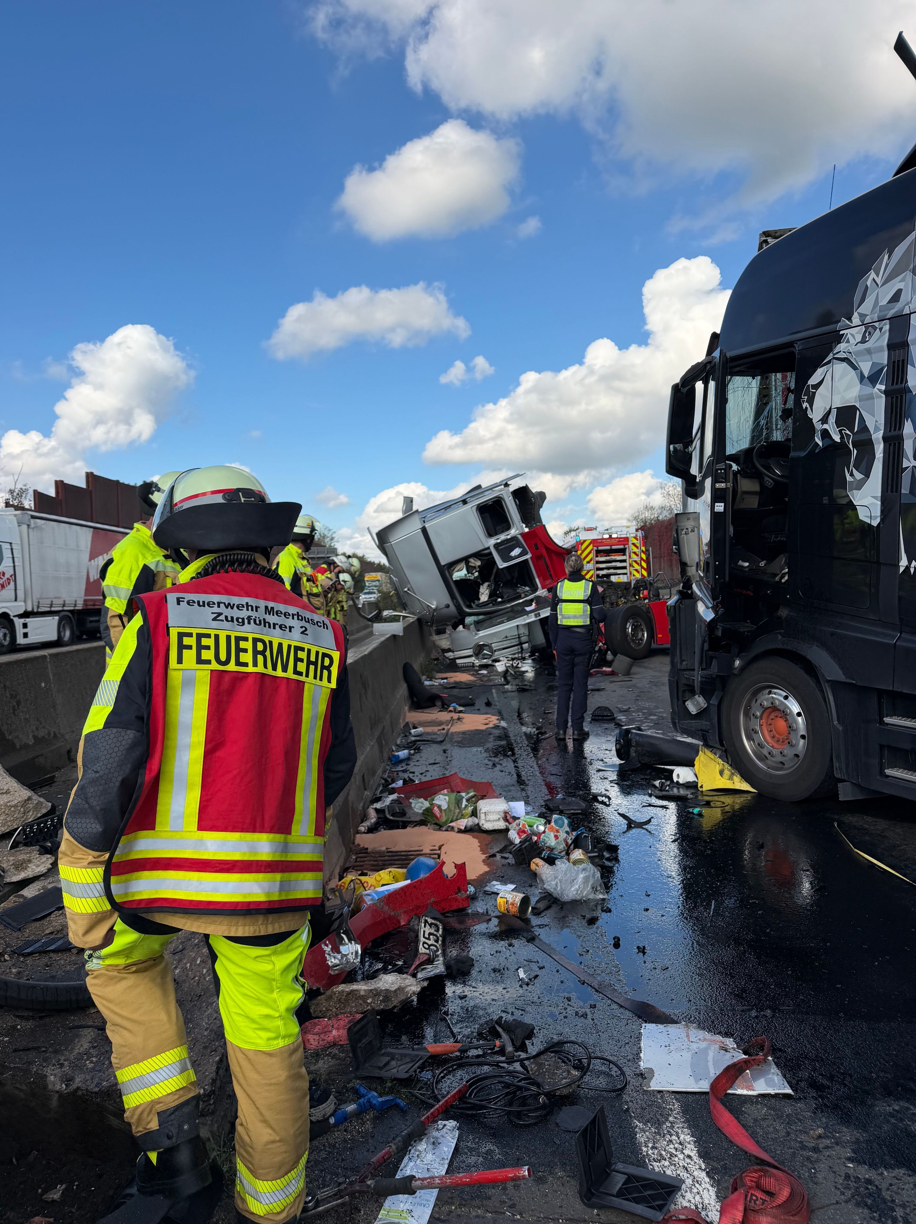 Einsatzkräfte sind bei einem Unfall auf einer Autobahn beschäftigt. Nach zwei Verkehrsunfällen ist die A57 in Richtung Niederlande auf unbestimmte Zeit voll gesperrt.