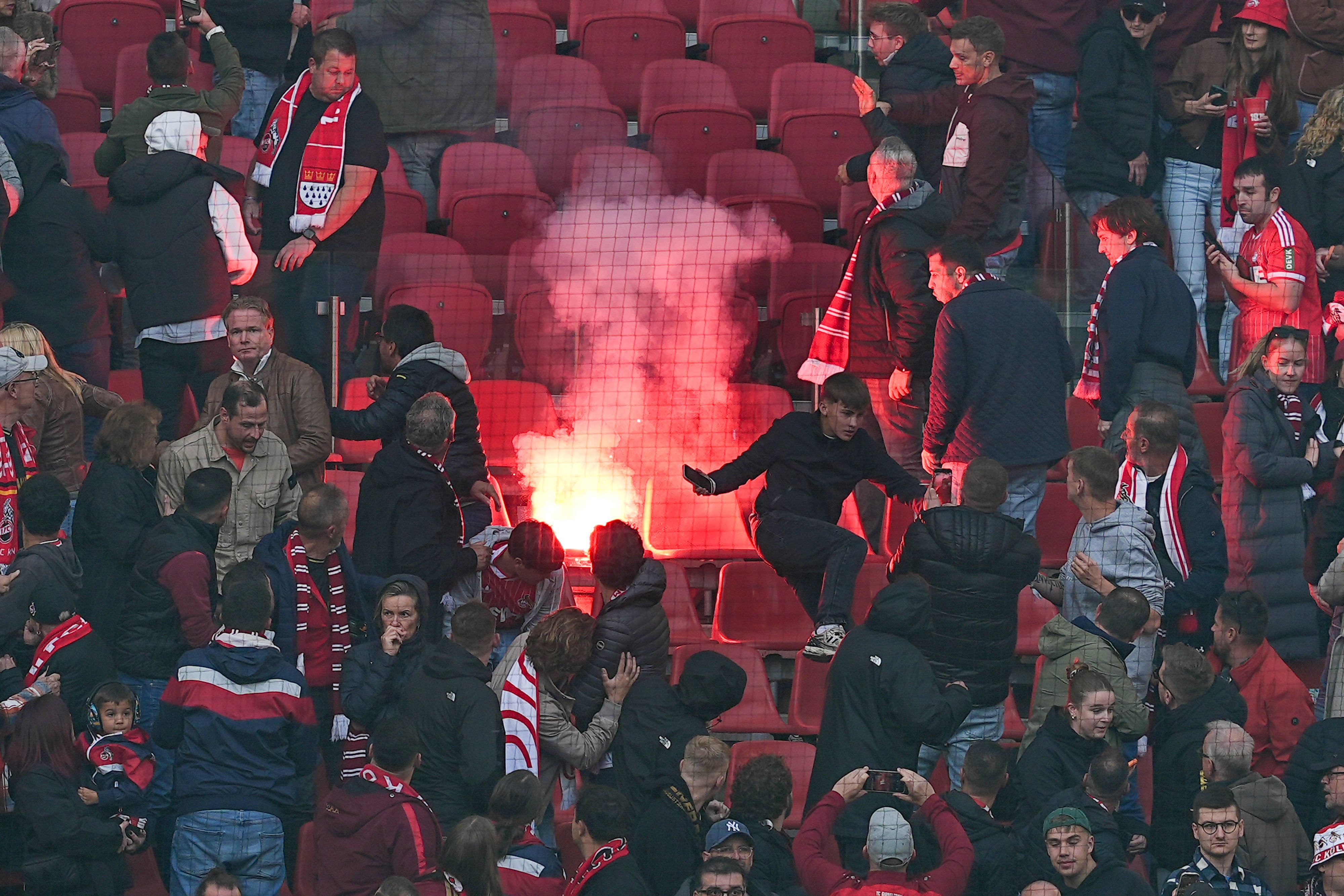 Kölner Fans flüchten vor geworfener Pyrotechnik.