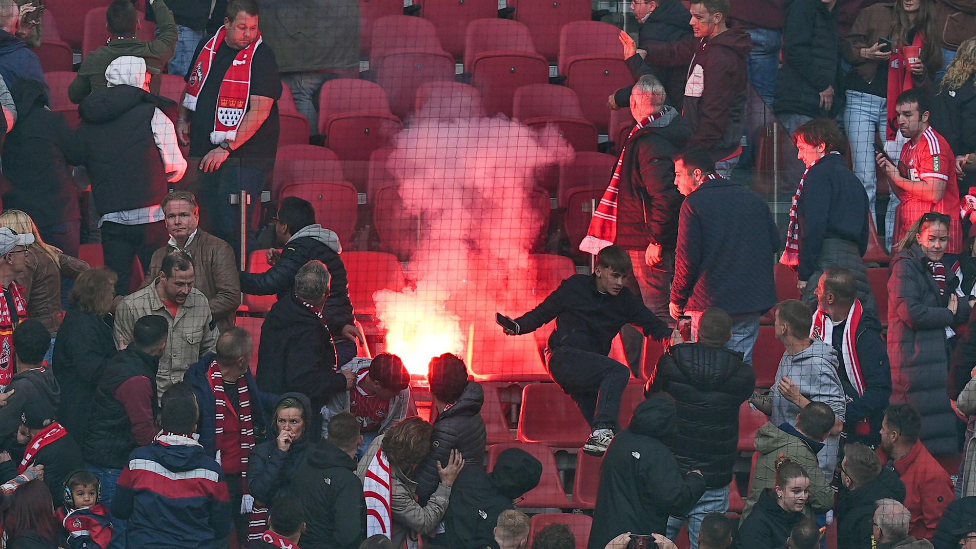 Kölner Fans flüchten vor geworfener Pyrotechnik.