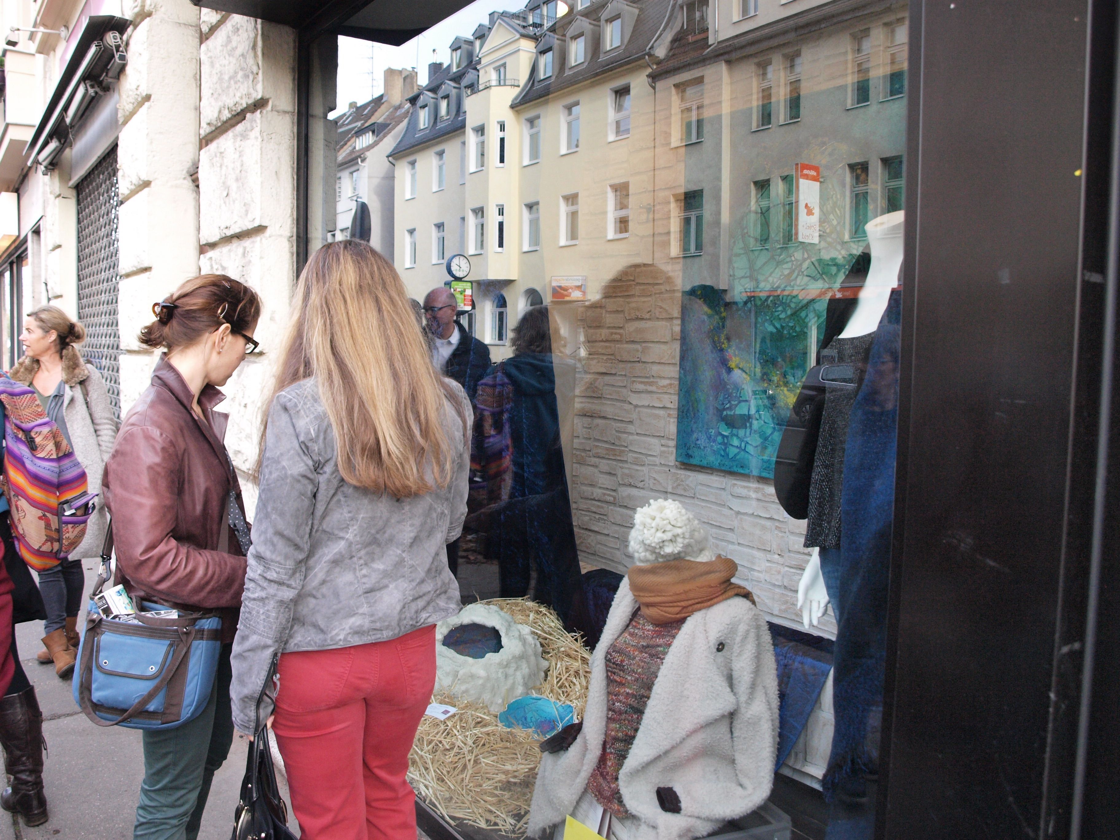 Zwei Frauen stehen vor einem Schaufenster und betrachten die Auslage.