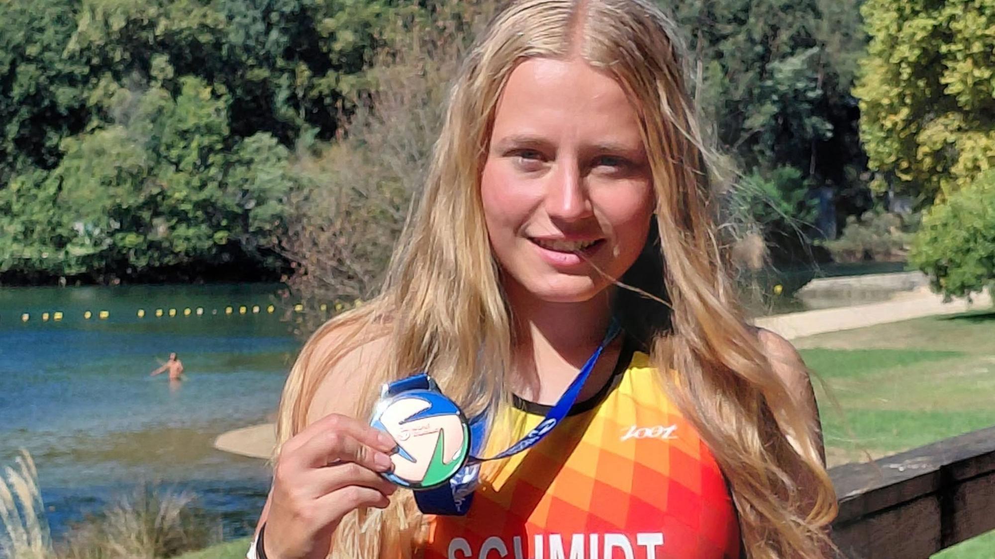 Zu sehen ist eine junge Frau mit Medaille.