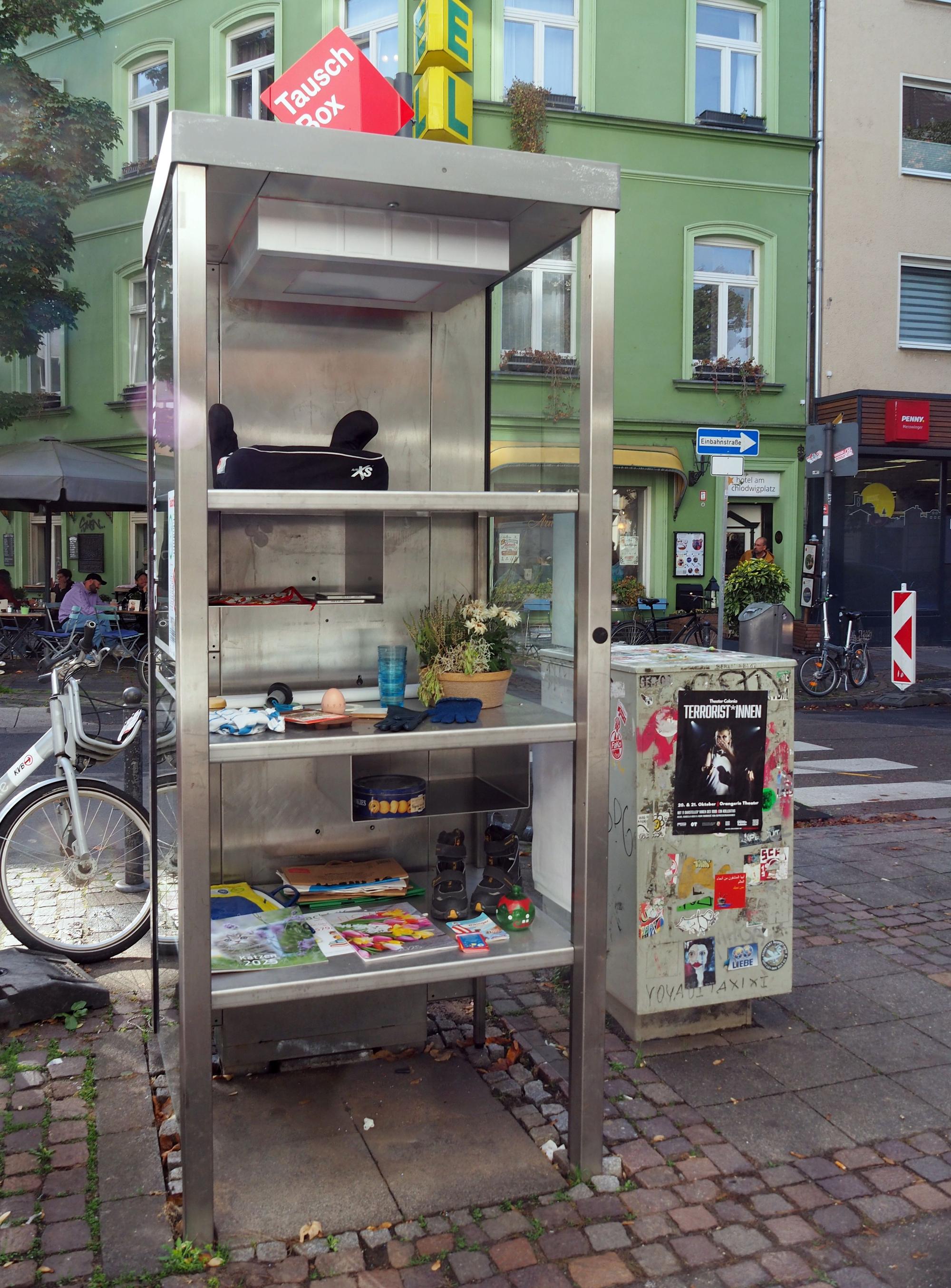 Eine alte Telefonzelle wurde mit Regalen ausgestattet.