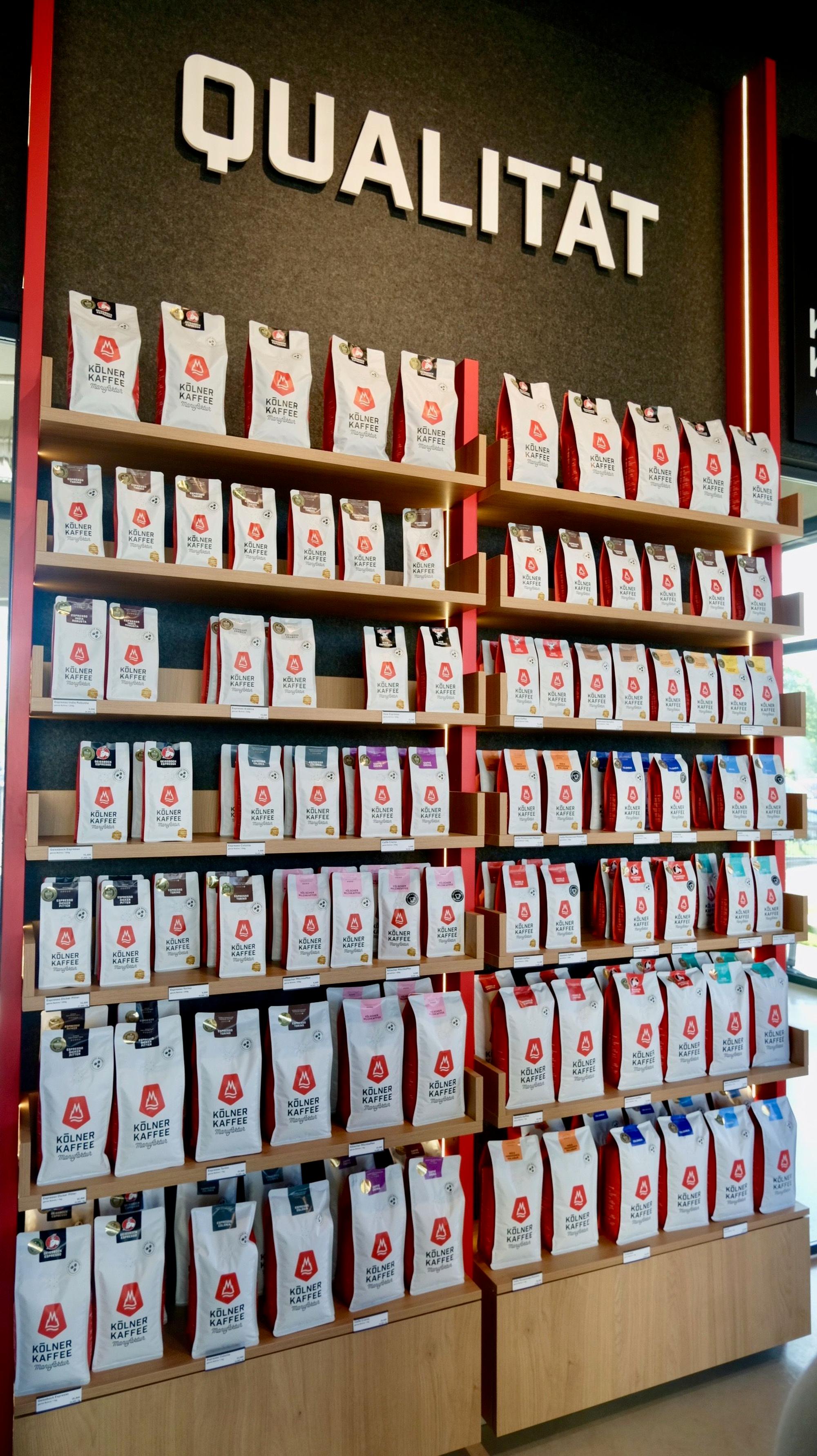 In einem Regal sind zahlreiche verschiedene Kaffeesorten einsortiert.