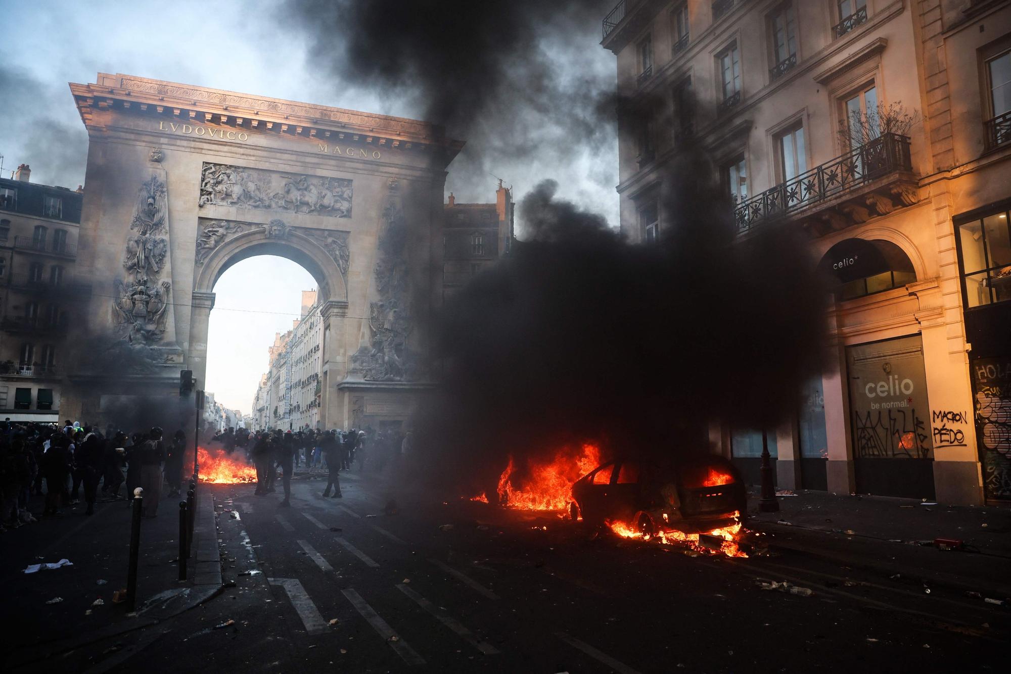 Demonstranten neben einem brennenden Auto in der Nähe der Porte Saint-Denis in Paris.