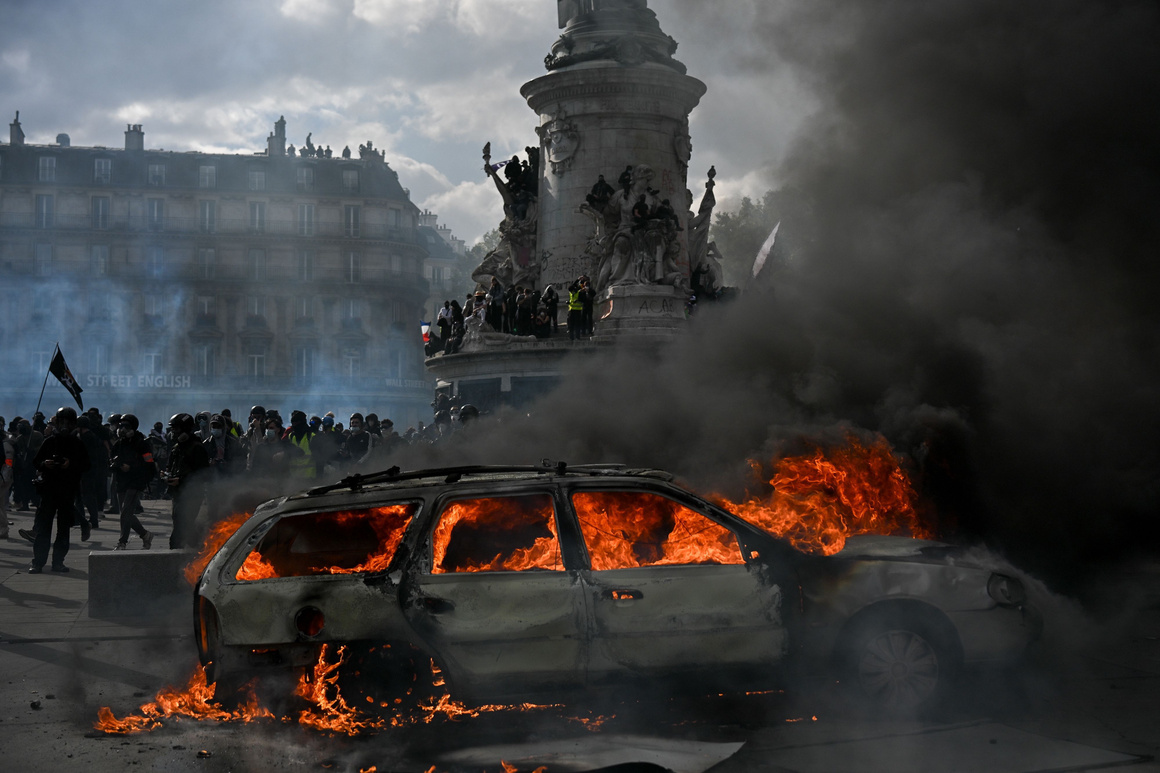 Auf dem Place de la République brennt ein Auto, während es zu Zusammenstößen zwischen Demonstranten und Polizeikräften kommt.
