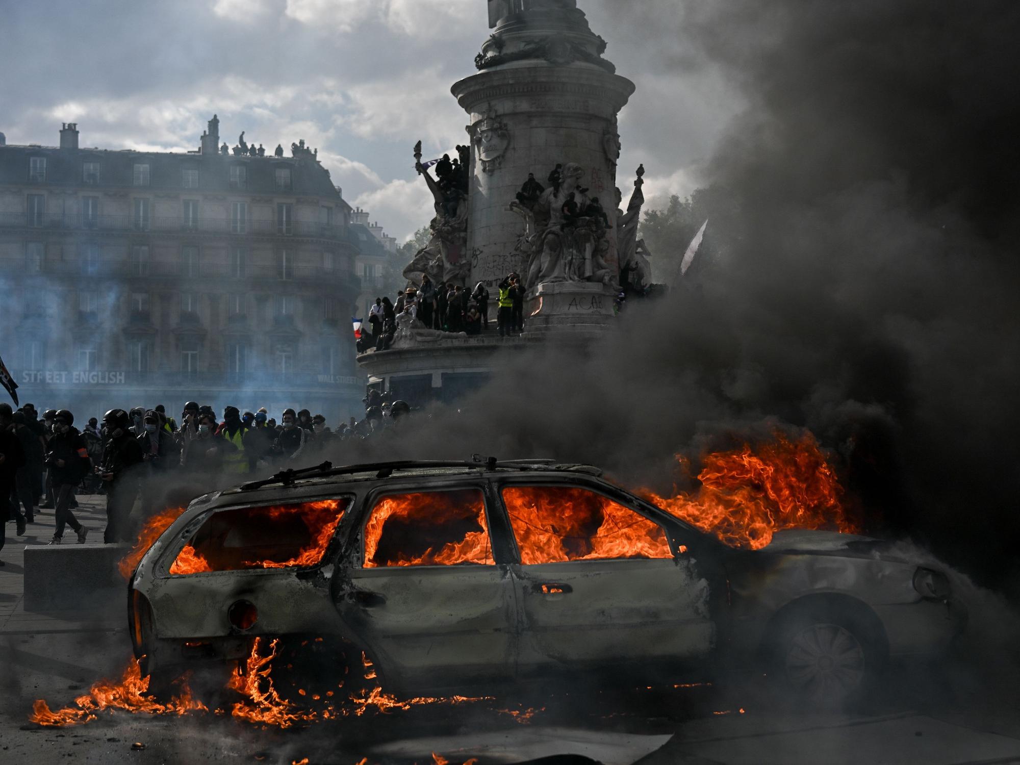 Auf dem Place de la République brennt ein Auto, während es zu Zusammenstößen zwischen Demonstranten und Polizeikräften kommt.