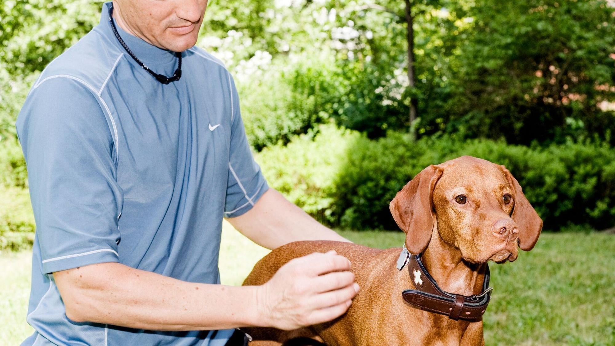 Ein Mann streichelt seinen Hund