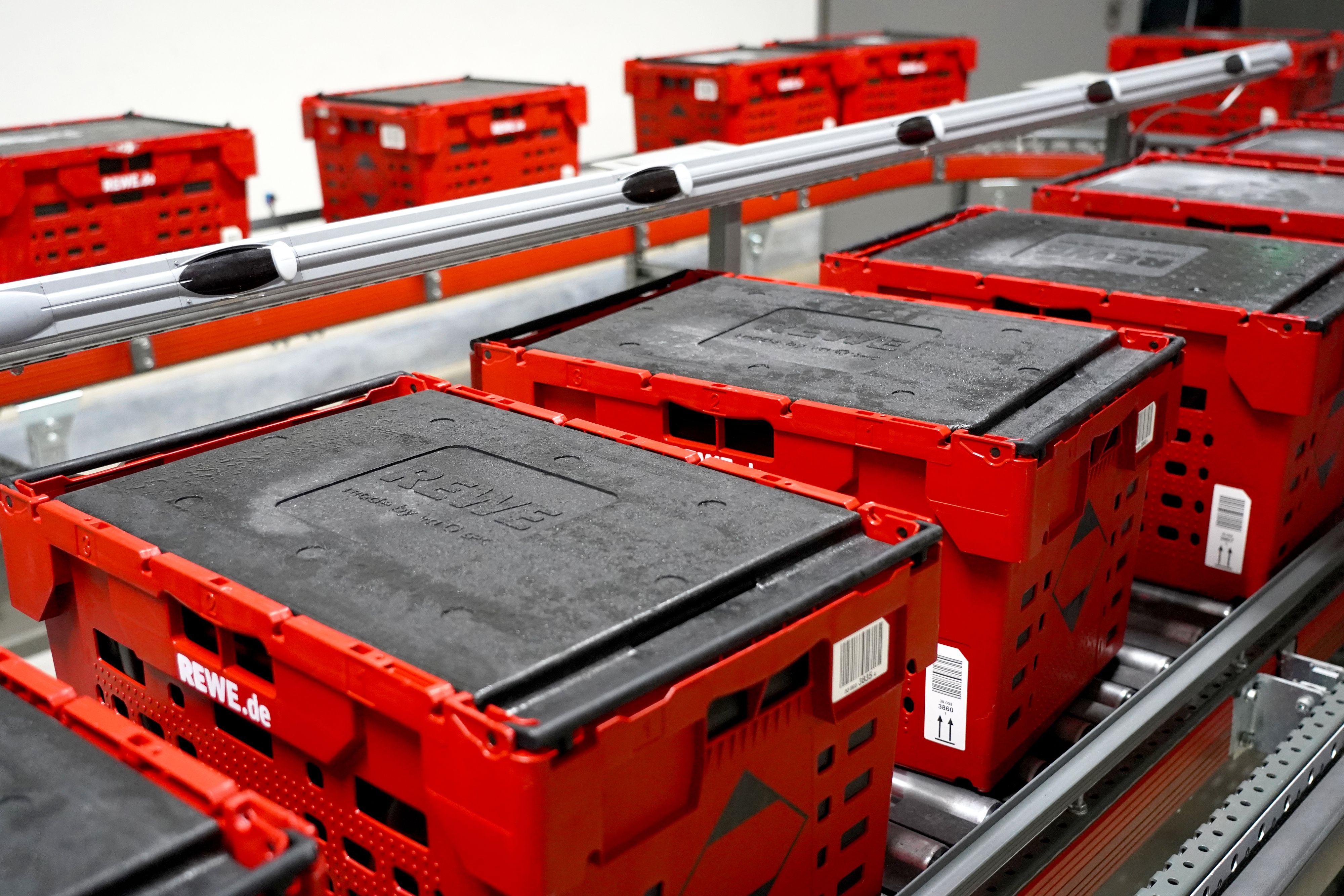 Rewe-Kühlboxen auf einem Laufband im Logistikzentrum in Köln