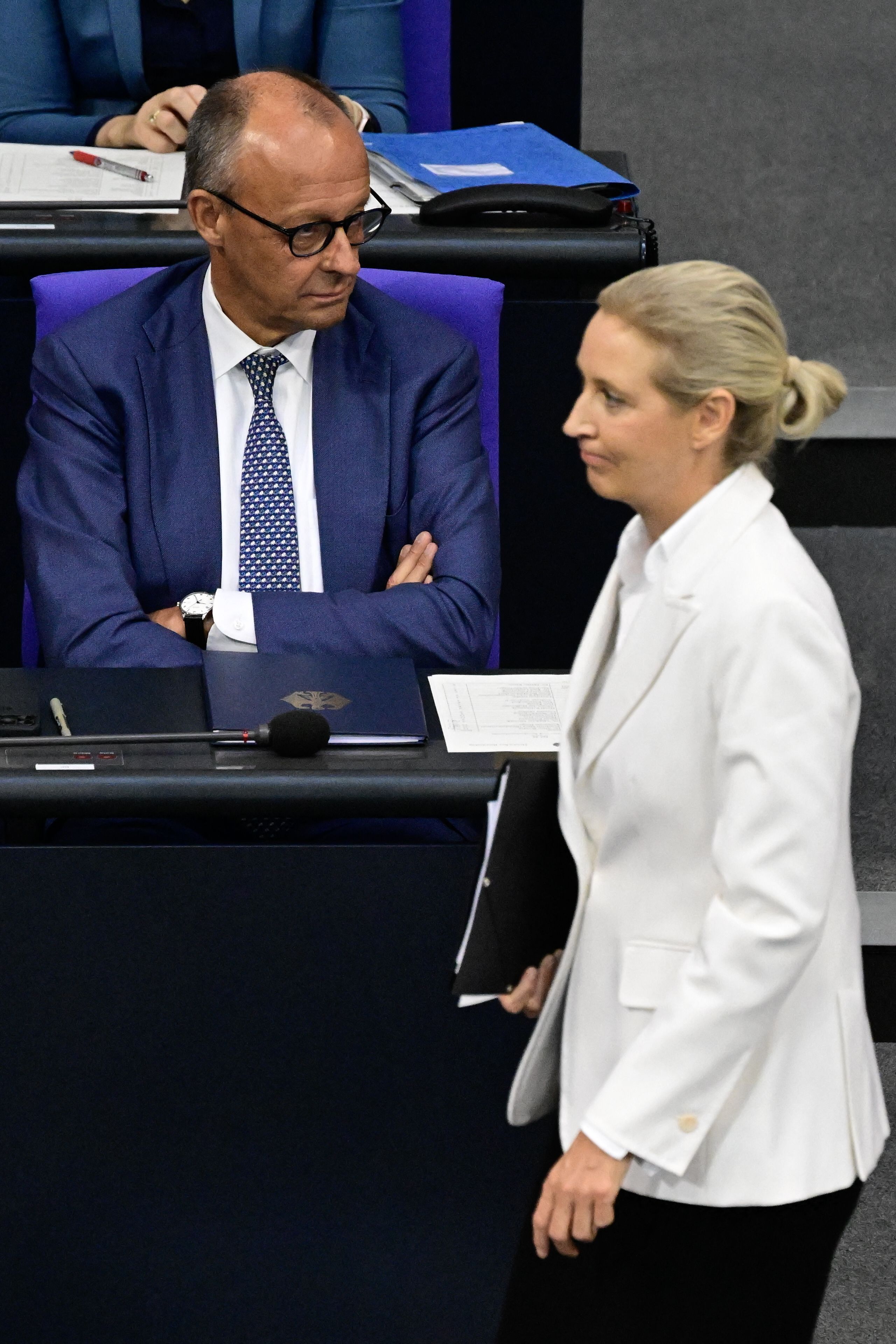 Bundeskanzler Friedrich Merz (CDU) im Bundestag. Im Vordergrund geht AfD-Chefin Alice Weidel entlang. (Archivbild)