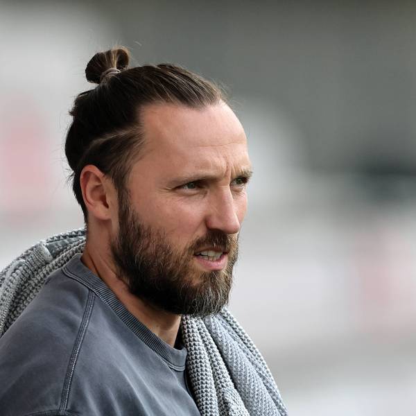 Marco Höger steht in Zivil am Spielfeldrand.