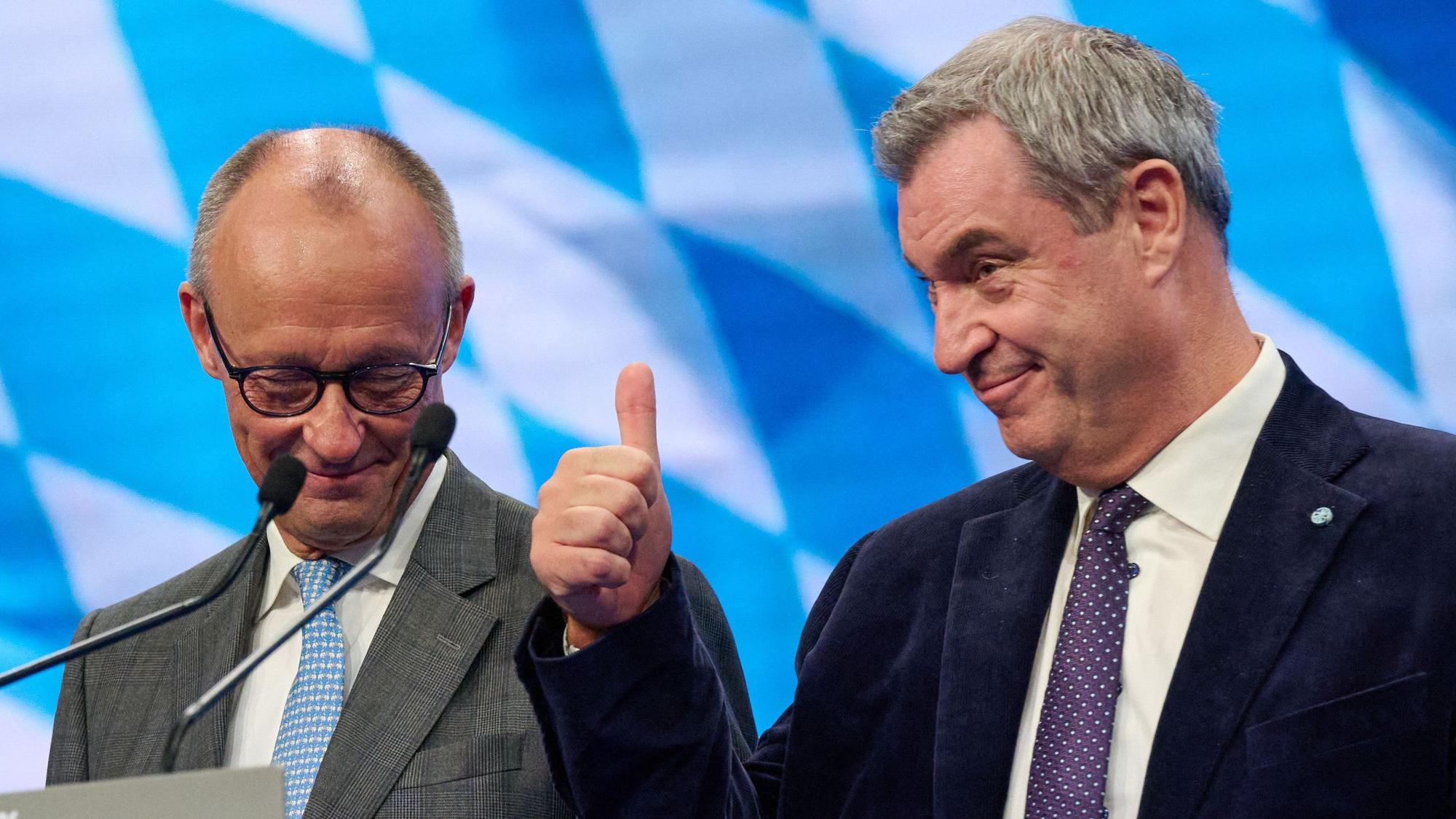 Der CDU‑Vorsitzende und Bundeskanzler Friedrich Merz (l.) und Markus Söder, CSU-Vorsitzender, stehen zum Abschluss des CSU‑Parteitags zusammen auf der Bühne.