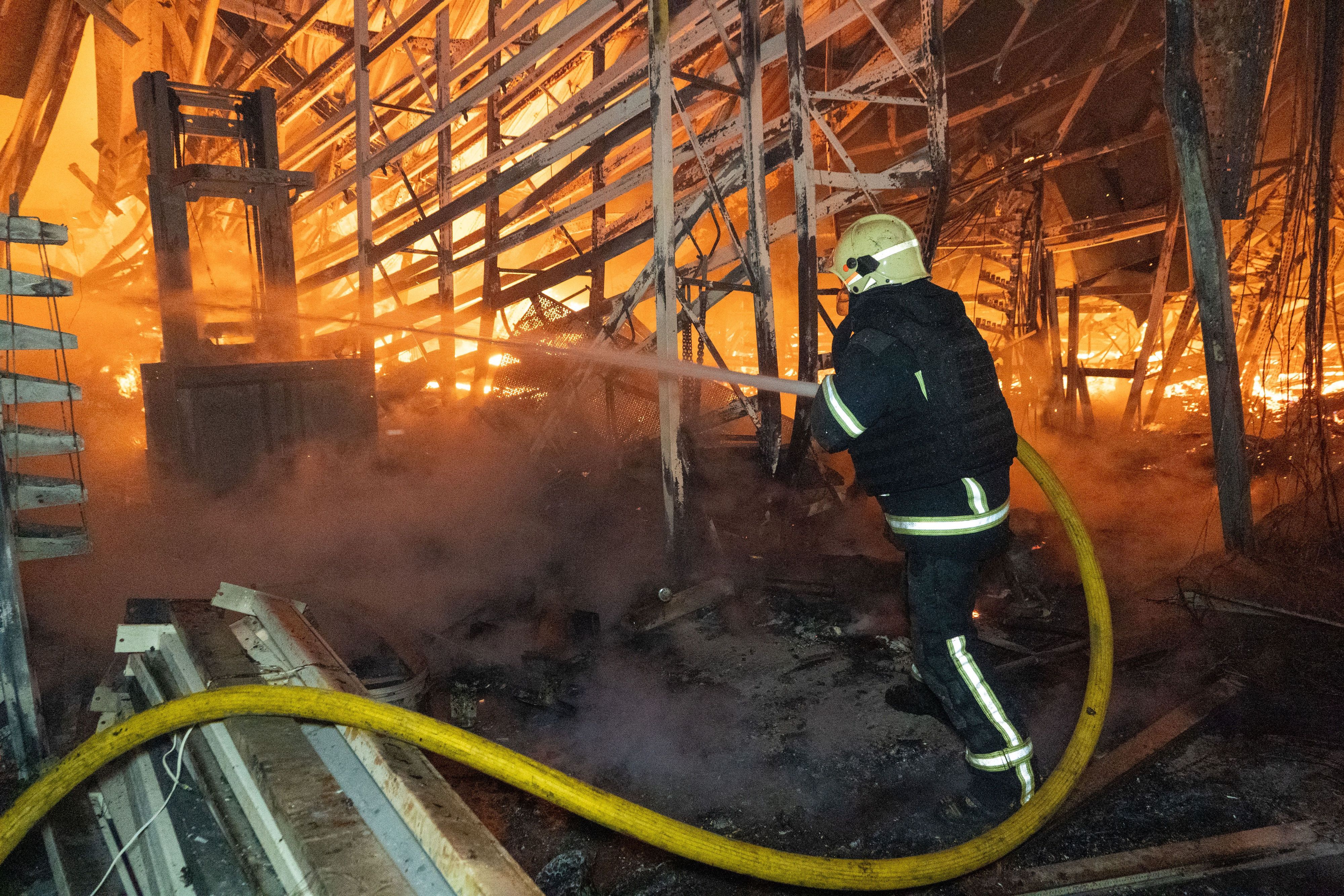 Ein Feuerwehrmann versucht, nach einem russischen Luftangriff am 25. Oktober einen Brand in einem Einkaufszentrum in Charkiw zu löschen.