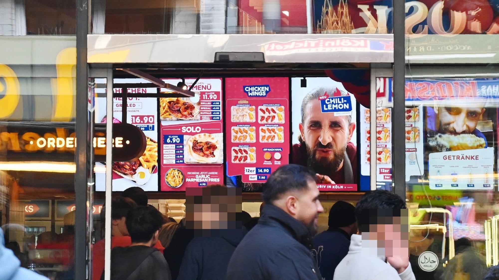 20.10.2026 Köln. Der Fast-Food-Imbiss Nhas City Chicken an der Breite Straße hat Ende September eröffnet. Noch immer bilden sich zeitweise Warteschlange vor dem Laden, der inbesondere durch Social Media seine Aufmerksamkeit bezieht. Foto: Alexander Schwaiger