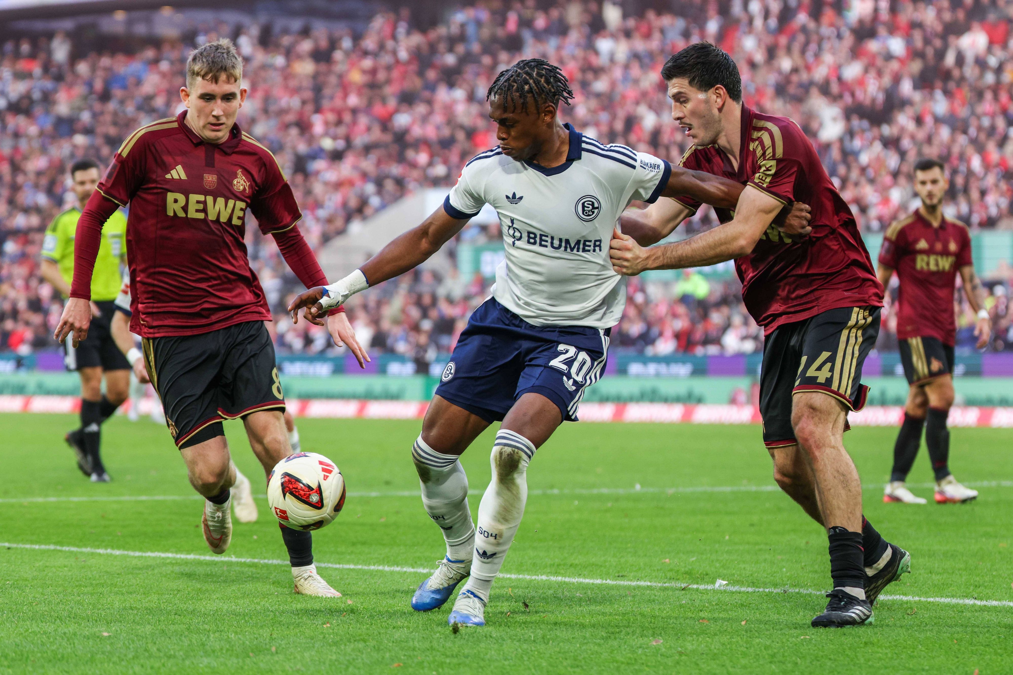 Junior Adamu (Schalke 04) und Luka Lochoshvili (1. FC Köln) im Zweikampf am 24. Oktober 2026.