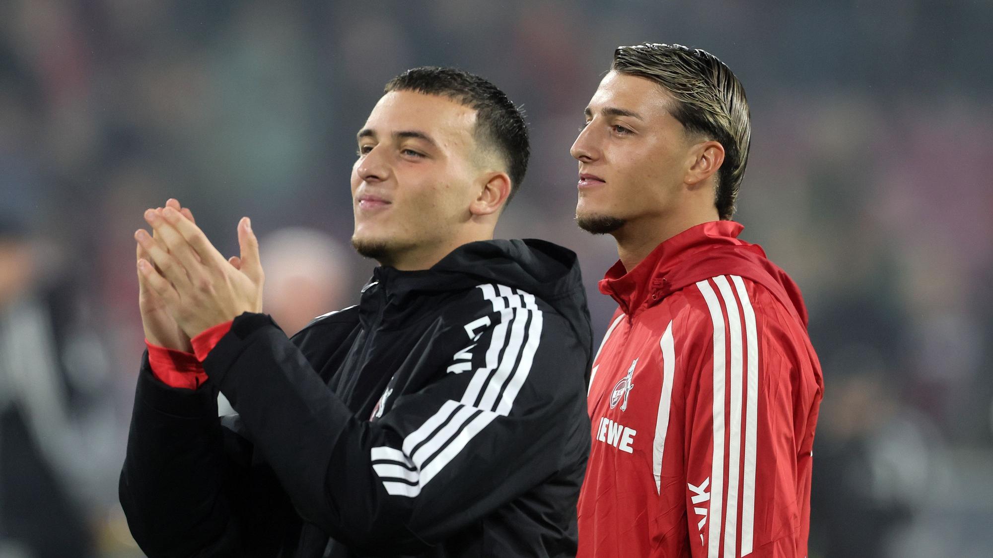 Said und Malek El Mala vom 1. FC Köln feiern nach Spielende mit den Kölner Fans.