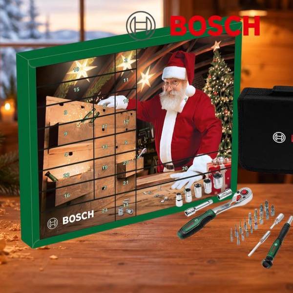 Grüner Bosch Adventskalender 2026 mit Weihnachtsmann an der Werkbank, davor Werkzeugtasche, Ratsche, Steckschlüsseleinsätze, Bits, Präzisions-Schraubendreher, Flaschenöffner, Cuttermesser und Wasserpumpenzange auf einer Holzwerkbank mit Hobelspänen und Kerzen