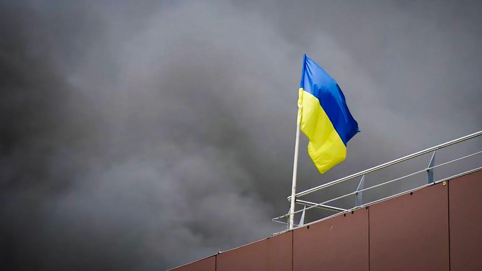 HANDOUT - 03.07.2024, Ukraine, Dnipro: Auf diesem von der Regionalverwaltung Dnipropetrowsk veröffentlichten Foto weht die ukrainische Flagge, während nach einem russischen Raketenangriff Rauch aufsteigt. (zu dpa: «Ukraine: Tote und Verletzte nach russischen Angriffen») Foto: Uncredited/Dnipro Regional Administration/AP/dpa +++ dpa-Bildfunk +++