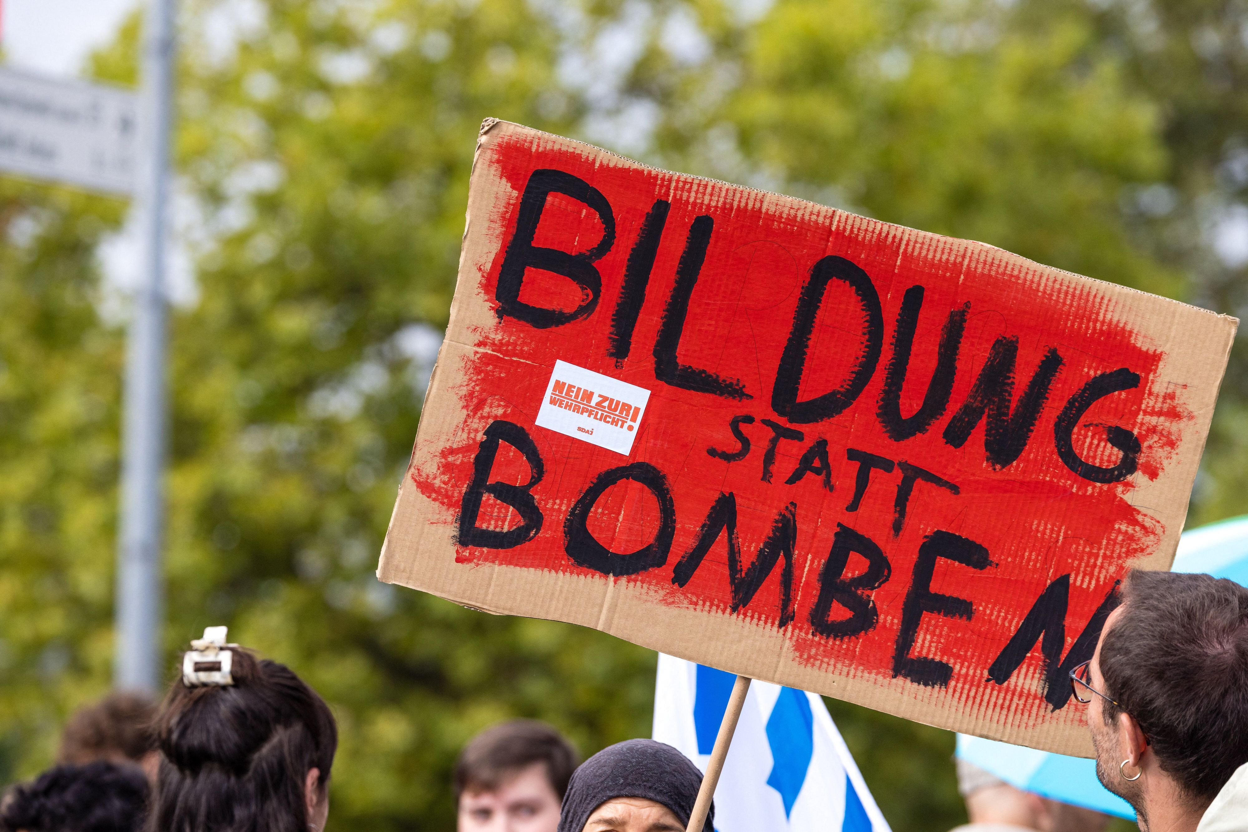 „Bildung statt Bomben“ steht auf dem Plakat eines Teilnehmers einer Demonstration. Gegen Wehrpflicht und Sozialkürzungen richtet sich auch „Gen Z regelt“. (Symbolbild)