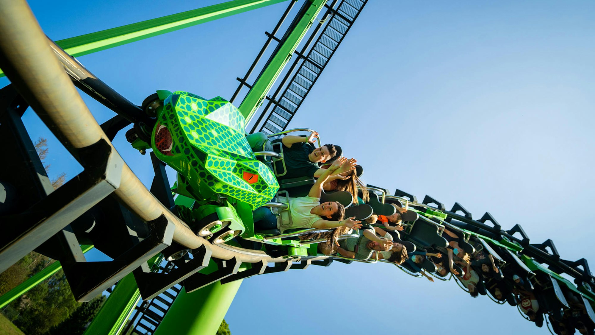 Menschen fahren auf einer Achterbahn, die wie eine Schlange aussieht