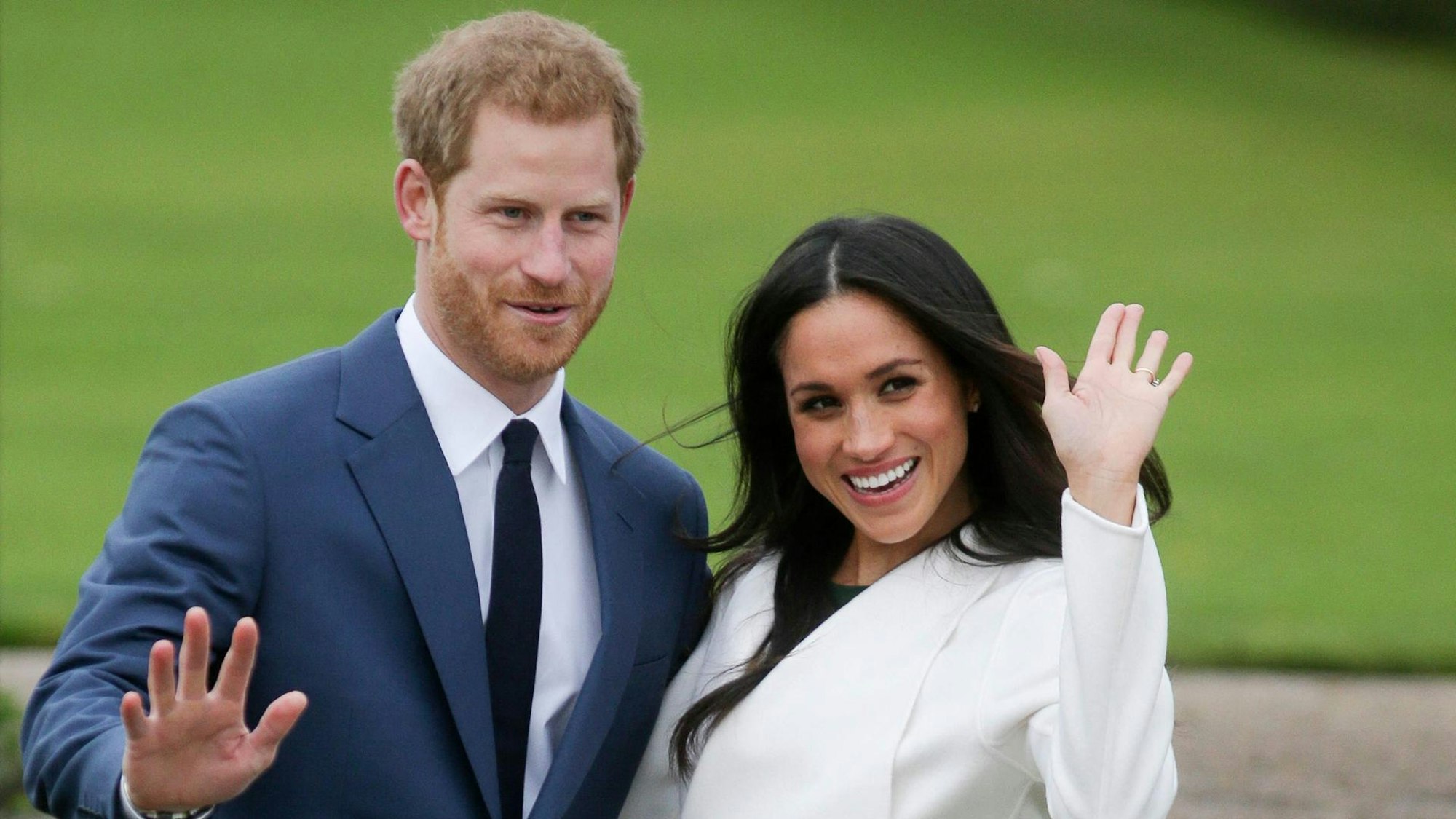 Prinz Harry und Herzogin Meghan winken bei einem öffentlichen Termin.