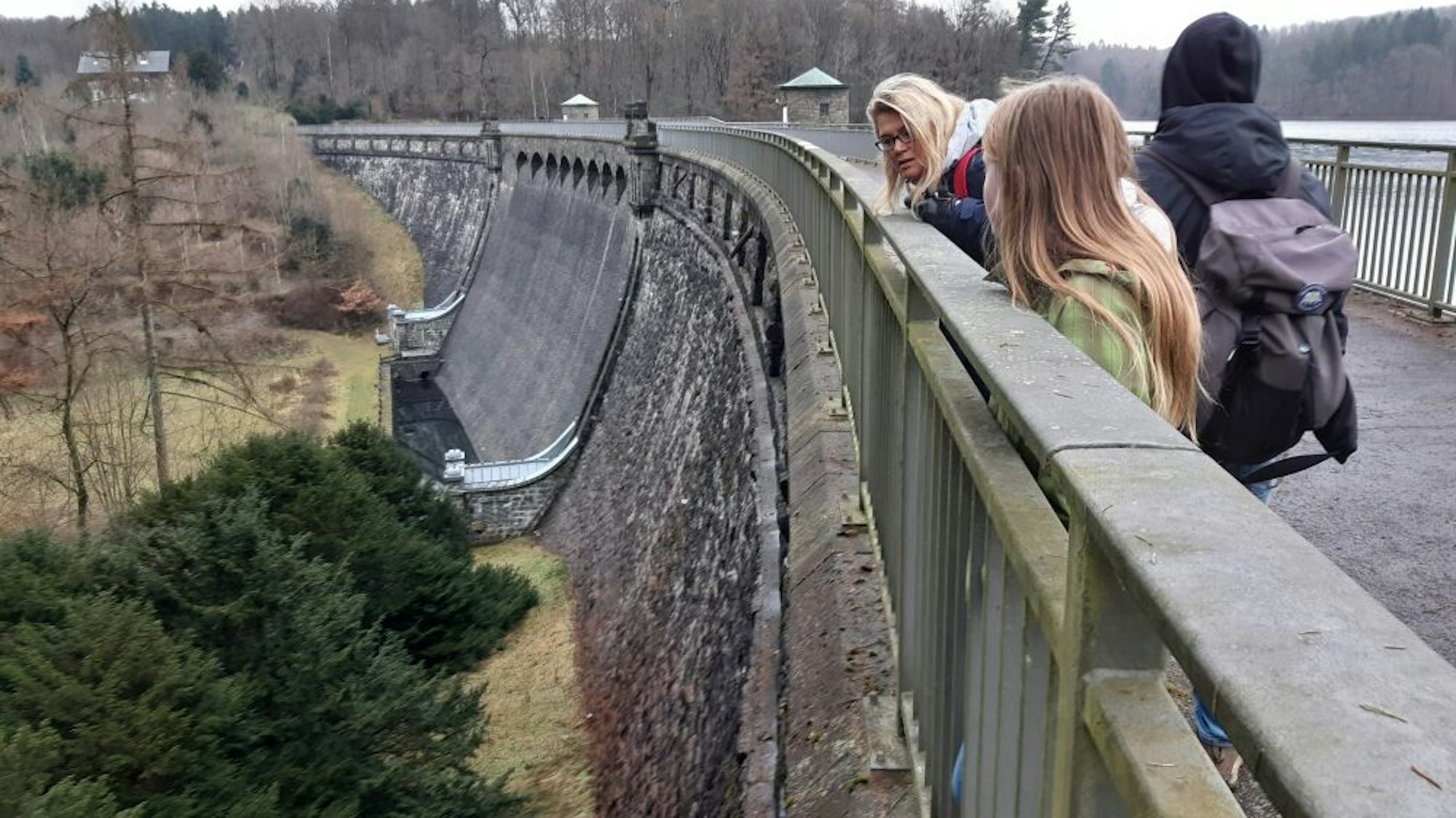 Menschen stehen auf einer Brücke und gucken ins Tal hinunter.