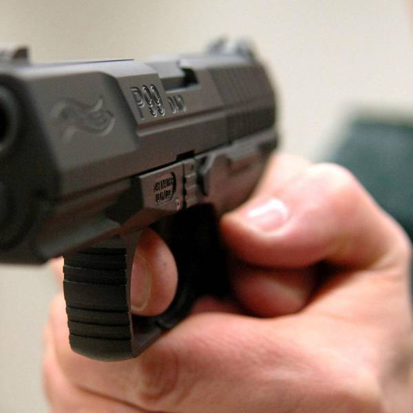 Ein Mann hält eine Waffe in der Hand.