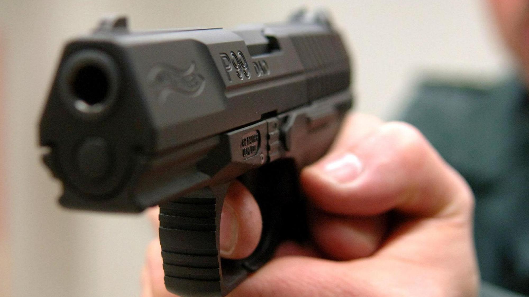Ein Mann hält eine Waffe in der Hand.