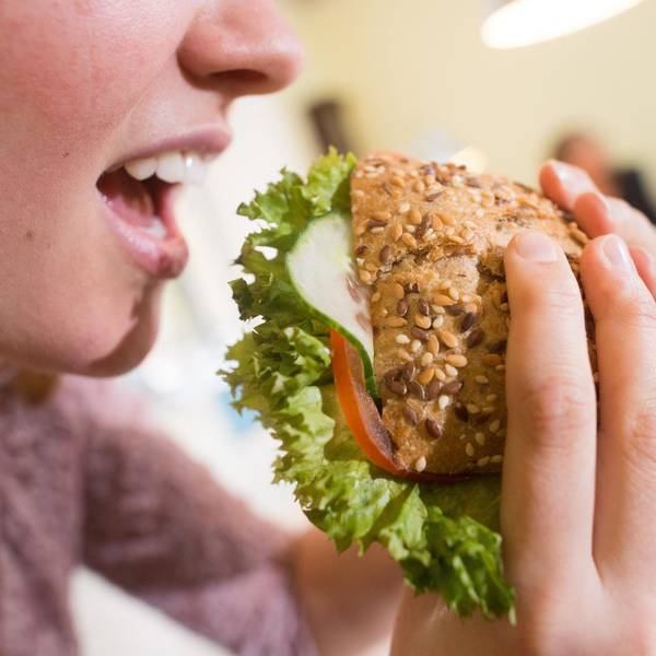 Frau beisst in Brötchen