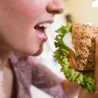 Frau beisst in Brötchen