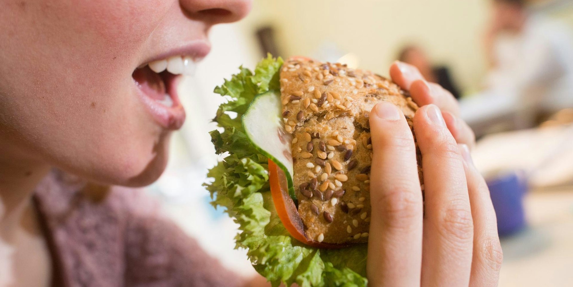 Frau beisst in Brötchen