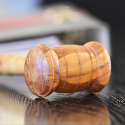 Ein Holzhammer liegt im Gericht auf dem Tisch eines Richters.