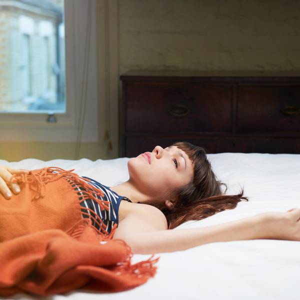 Eine Frau liegt im Bett und starrt an die Decke