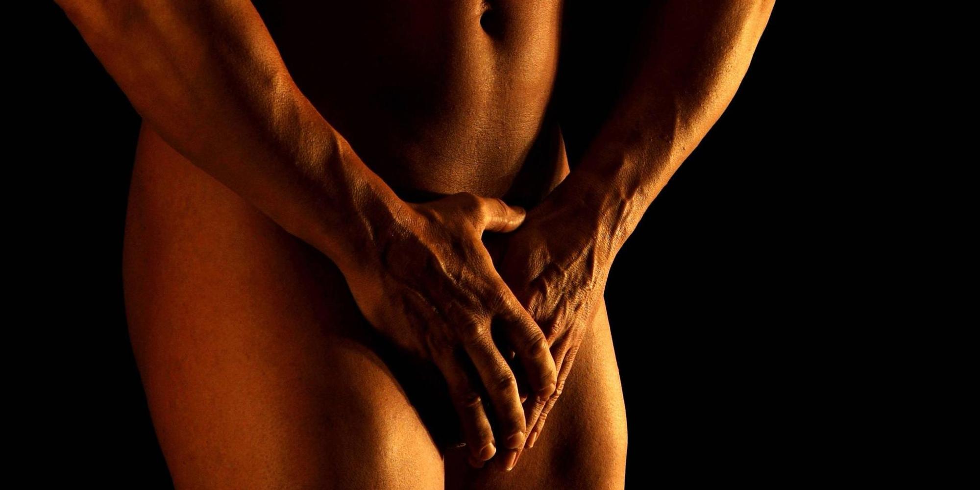 Mann hält sich seine Hände vor den Penis