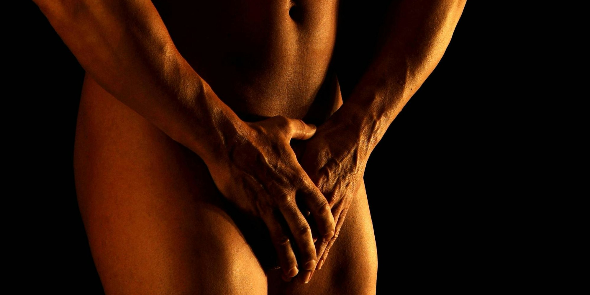 Mann hält sich seine Hände vor den Penis