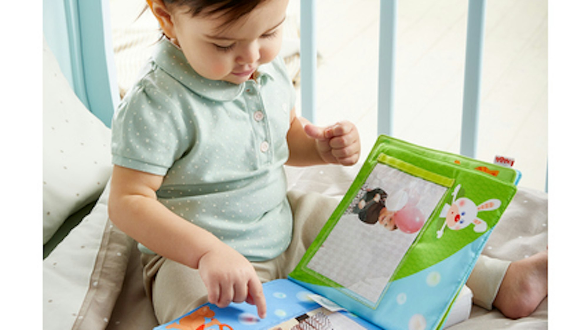 Ein Baby guckt ein Fotobuch an.