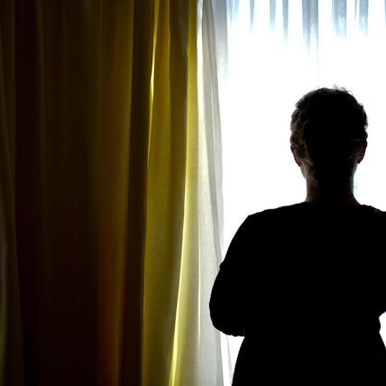 Frau_steht_vor_Fenster