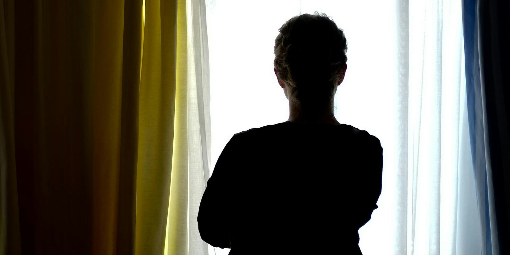 Frau_steht_vor_Fenster