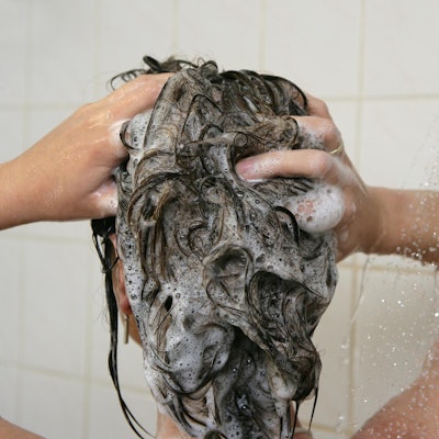 Frau wäscht sich die Haare