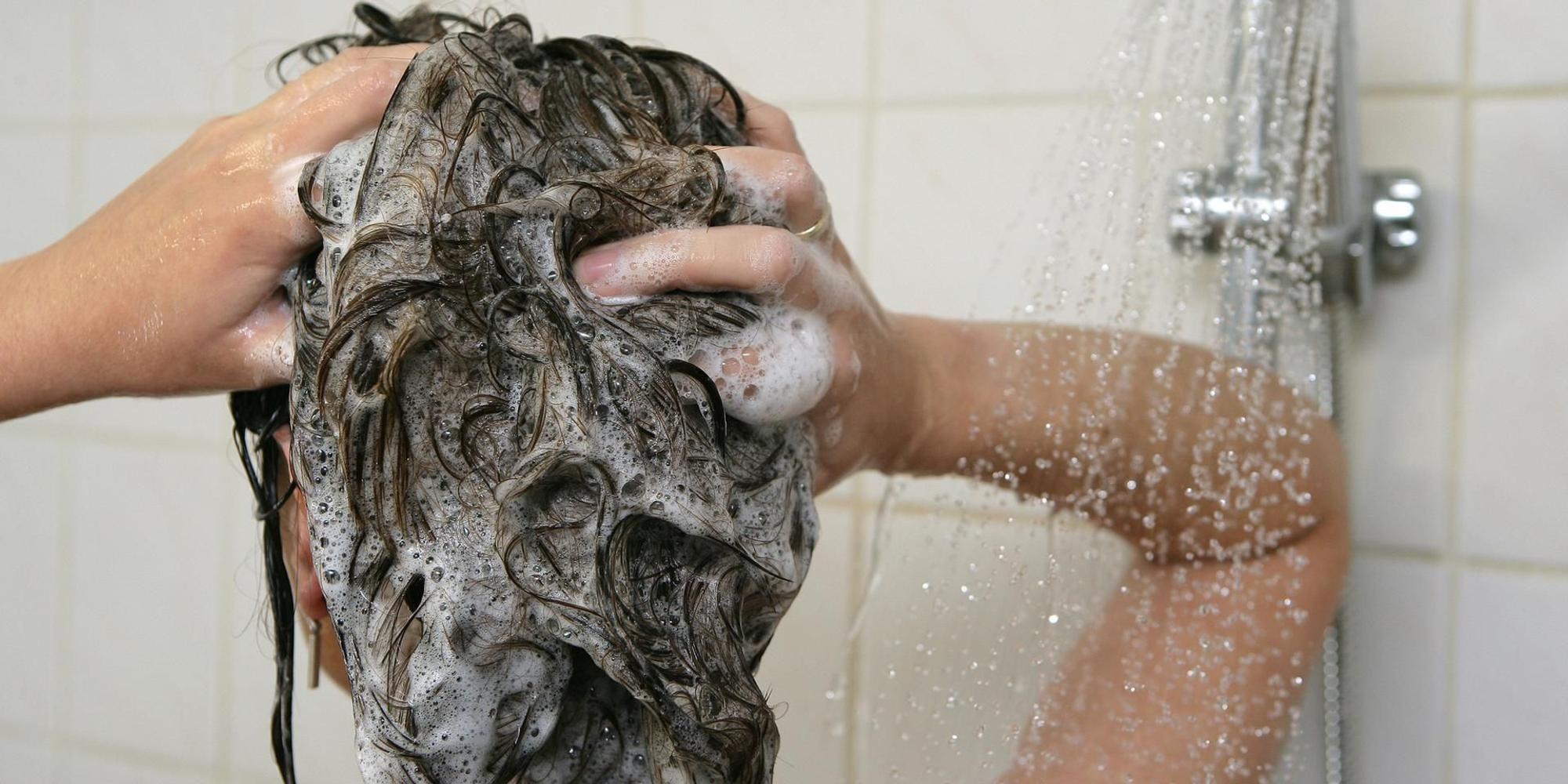 Frau wäscht sich die Haare