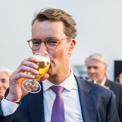 Hendrik Wüst trinkt ein Bier