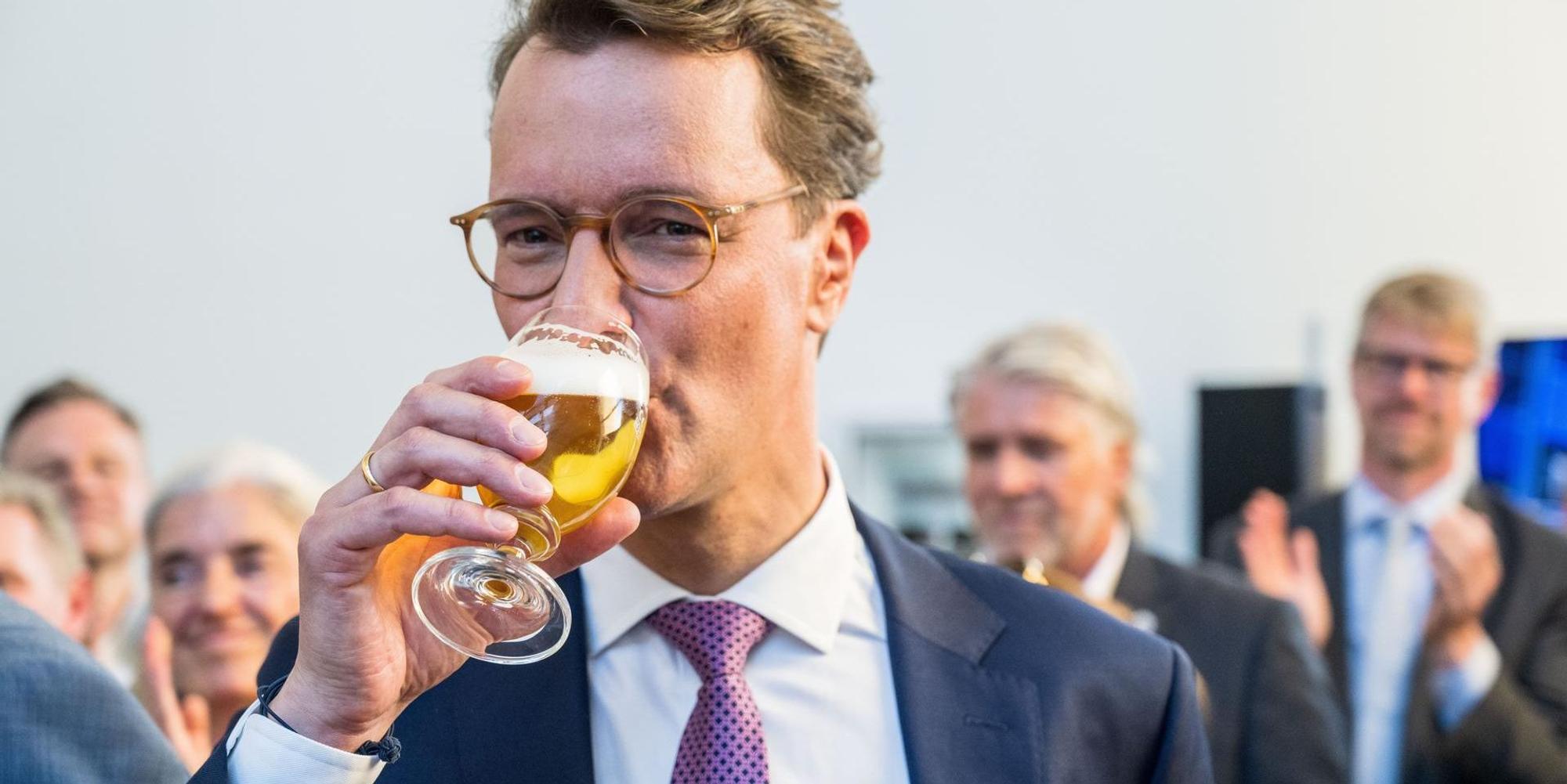 Hendrik Wüst trinkt ein Bier