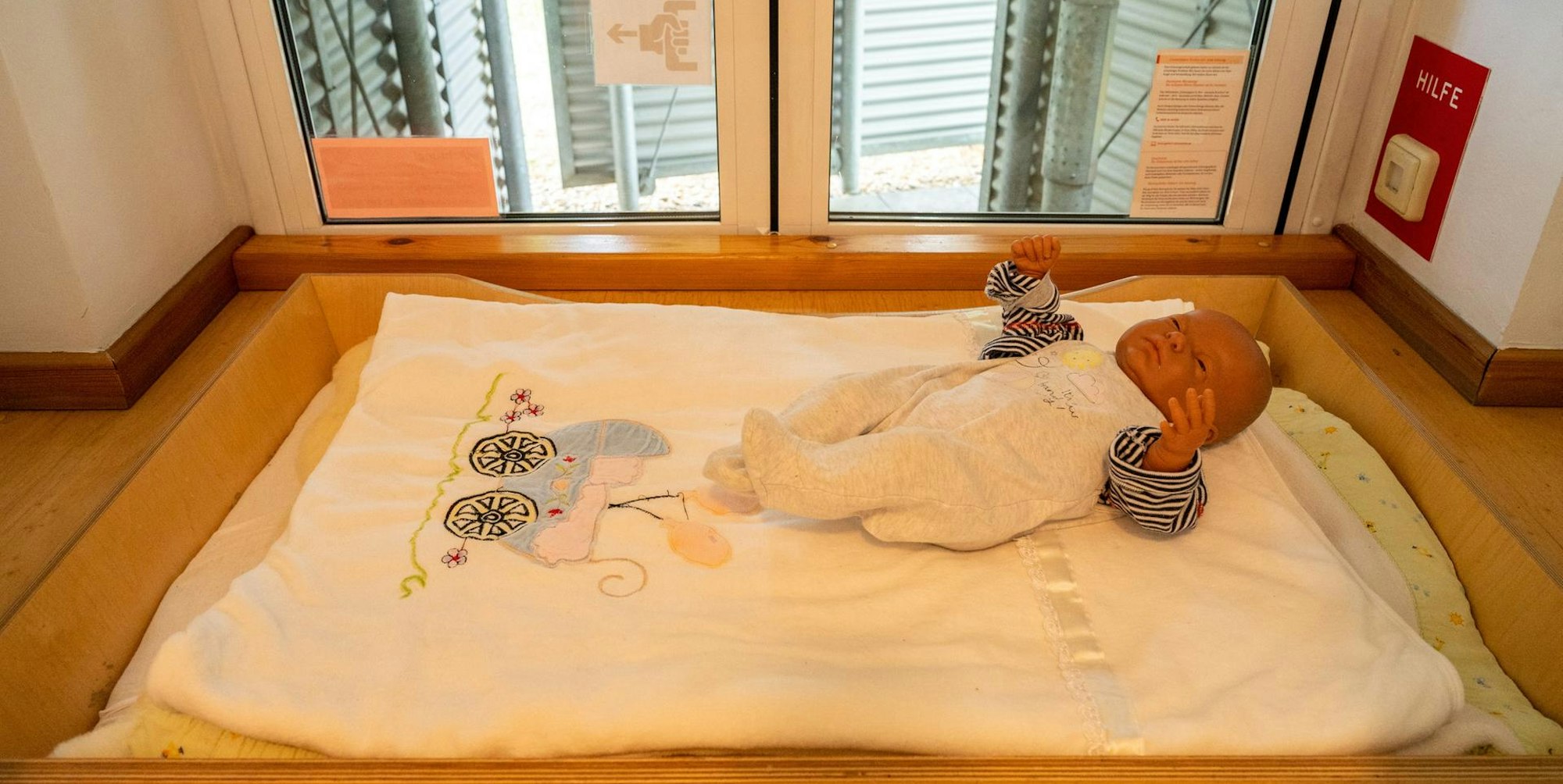 Eine Puppe liegt in der Babyklappe Köln.