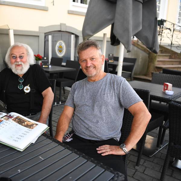 Wirt Jonny und sein Sohn Carsten Johnen sitzen in seinem Lokal an einem Tisch.