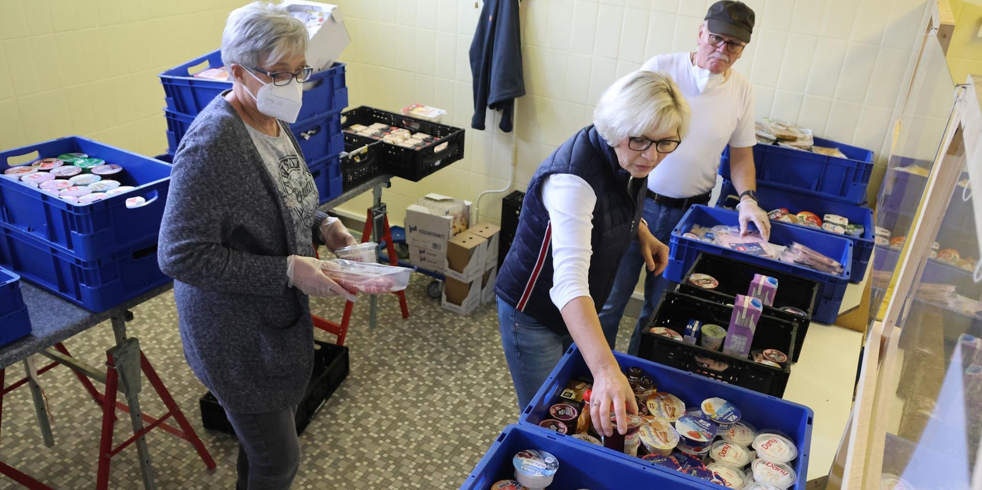 Frauen sammeln Lebensmitteln in Kisten.